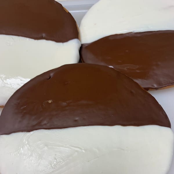 Close-up of several black and white cookies with half chocolate and half vanilla frosting.