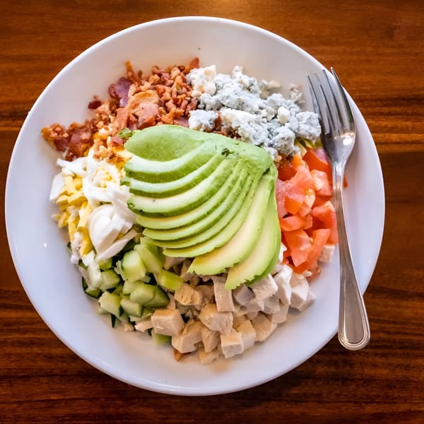 A Pickles Deli Cobb salad with avocado, bacon, blue cheese, chicken, egg, and tomatoes.